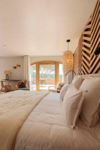 纳博讷Château L'Hospitalet Wine Resort Beach & Spa的一间卧室设有一张大床和大窗户