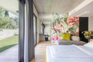 加尔达湖滨OLEEVA Garda Living的卧室配有一张床,墙上挂有绘画作品