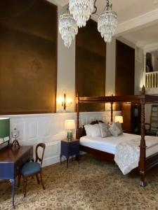 伯恩茅斯朗特里庄园酒店的一间卧室配有一张床、一张桌子和吊灯。