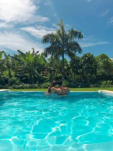 拉斯加勒拉斯Apart-Hotel Garden Villa的两人在棕榈树游泳池里
