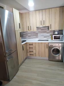 曼萨纳雷斯CENTRO HISTORICO的厨房配有木制橱柜和不锈钢冰箱。
