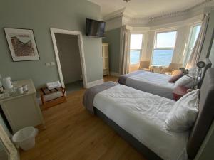 班多伦Rolling Wave Guesthouse的酒店客房设有两张床和电视。