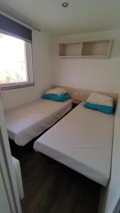 鲁西隆地区卡内MOBIL HOME camping **** Canet en Roussillon的小型客房 - 带2张床和窗户