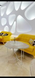 科尔多瓦Hotel Boutique Suite Generis, Premiado El hotel más acogedor de España的客厅配有黄色的沙发和桌子