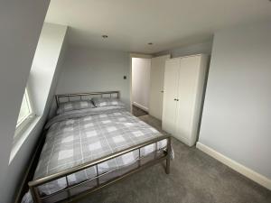 伦敦3 bed Apartment in Colliers Wood的一间卧室设有一张床和白色的墙壁