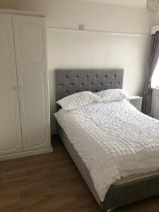 Llandrillo-yn-Rhôs3 bed bungalow Penrhyn Bay Llandudno的卧室配有带白色棉被的床