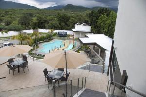 加尔潘La Terraza Hotel的户外庭院设有游泳池、桌子和遮阳伞。