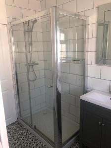 Llandrillo-yn-Rhôs3 bed bungalow Penrhyn Bay Llandudno的浴室里设有玻璃门淋浴