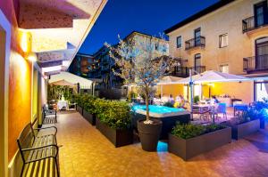 维罗纳Hotel Fontana Verona的户外庭院设有游泳池和桌椅。