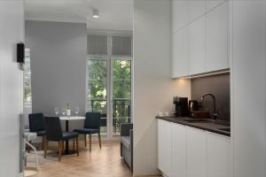 斯维诺乌伊希切Villa 44 -V44-的厨房配有白色橱柜和桌椅