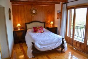 托雷瓦尔德圣佩德Casa del Río的一间卧室配有一张带两盏灯的床和一扇窗户。