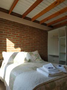 特来凡林Masia del Valle的一间卧室设有一张床和砖墙