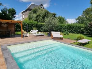 讷维克VILLA MURA gite luxe avec piscine et spa campagne et grand air nouvelle Aquitaine Corrèze的庭院内的游泳池,配有桌椅