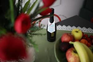 利多迪耶索罗Residence Mariavittoria的一瓶葡萄酒,坐在一盘水果旁边