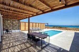 卡尔帕索斯Cato Agro 2, Seafront Villa with Private Pool的一个带桌椅的庭院和一个游泳池
