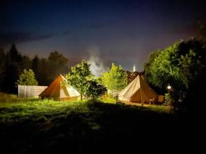 米科瓦伊基Pokoje u Basi Glamping Mikołajki的一群帐篷在晚上在田野里
