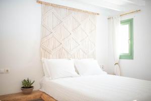 迈洛波塔斯拉万提斯精品酒店的卧室配有白色的床和窗户。