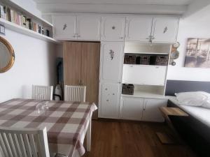 KanzelhöheHaus Enzian - Apartment Gerlitzen的一间厨房,内设白色橱柜和一张桌子