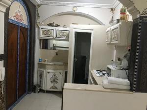 马拉喀什Flashback House的厨房设有一扇开放式门,通往带炉灶的厨房