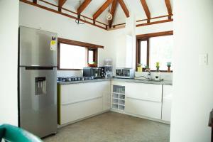 莱瓦镇Casa Dino en Villa de Leyva的厨房配有白色橱柜和不锈钢冰箱