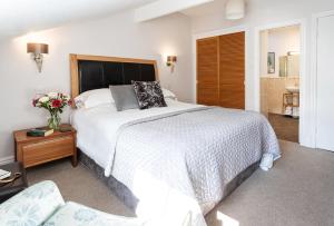 安布尔塞德诺伍德豪斯旅馆的卧室配有一张白色大床和一把椅子