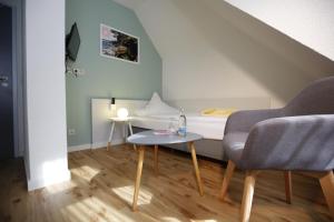 劳沙贝克酒店的小房间设有一张床、一张桌子和椅子