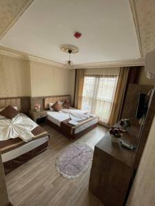 安塔利亚Özgür Hotel的一间卧室配有两张床、一张沙发和一张桌子