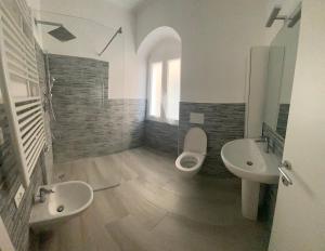 瓦里格提VILLA IRMA的浴室设有2个盥洗盆、卫生间和2面镜子。