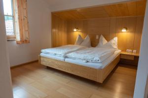 茵特斯托德Frühstückspension Haus Mayr的一间卧室配有带白色床单和枕头的床。