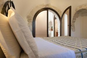 CrispianoMasseria Pilano的一间卧室设有一张床和一个拱形门廊