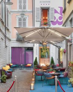 科莫73 Boutique Hotel的一个带桌椅和遮阳伞的庭院