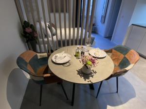 罗维尼Apartments Hidden paradise Rovinj的桌子上摆放着椅子,花瓶上放着花