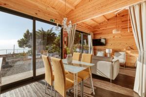 蓬塔杜帕戈Madeira Sunset Cottage - Nature Retreat的用餐室以及带桌椅的起居室。