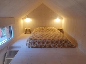 昂热Tiny House Cosy 2 - Angers Green Lodge的一间小房间的卧室,配有一张床铺