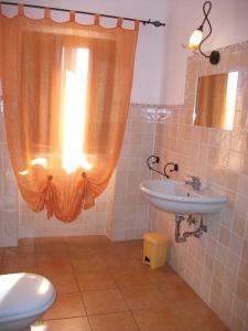 BolanoAgriturismo La Villa的一间带水槽和卫生间的浴室以及窗户。