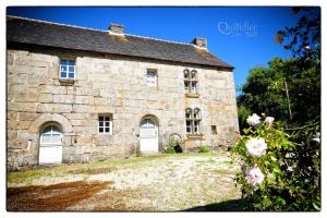 CommanaManoir Pors Braz - Gîte des Boudiged的白色门和鲜花的古老石屋