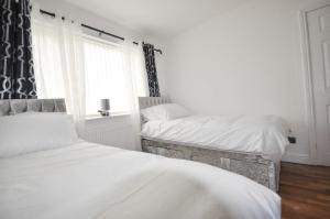 卢顿Modern 2 Bed Apartment的卧室设有两张单人床和窗户。