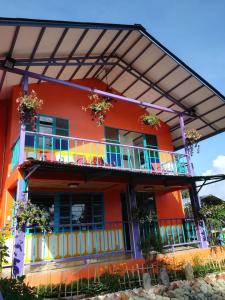 菲兰迪亚Finca San Miguel Filandia的一座橙色的建筑,设有阳台,鲜花盛开