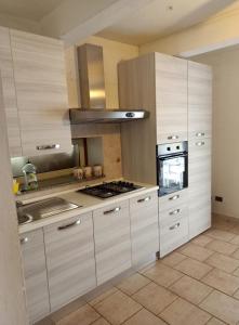 特罗佩阿Casa Vacanze Calabria的厨房配有白色橱柜和炉灶烤箱。