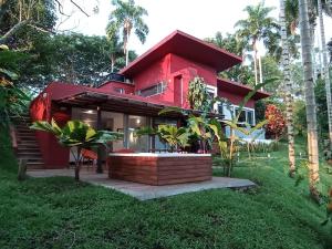 佩雷拉Tierra Negra Suite的棕榈树山上的红色房子