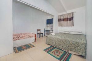 拉罗汤加穆里海滩天堂度假屋的一间小房间,配有两张床和厨房