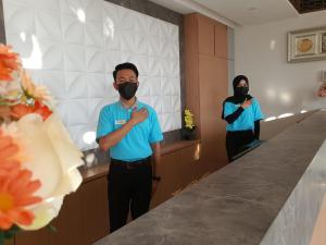 PadangluarMuara Hotel Bukittinggi的戴面具的男子在镜子前