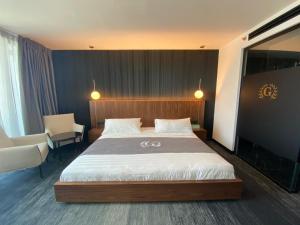提比里亚戈兰高地酒店 的一间卧室配有一张大床和一把椅子