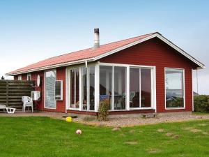 莱姆维Three-Bedroom Holiday home in Lemvig 1的红色的房子,设有大型滑动玻璃门