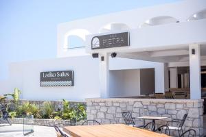 法里拉基Ladiko Suites - Faliraki的一间带桌椅和标志的餐厅