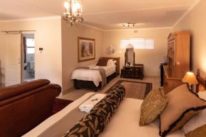 乔治Antiqua Guest House的一间卧室配有两张床,卧室内配有沙发