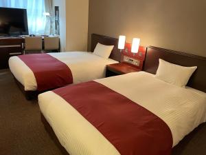 东京Ai Hotel Keikyu Kamata-ekimae的酒店客房配有两张床和一张书桌