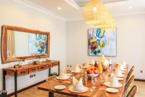 迪拜The S Holiday Homes - Stunning 5 Bedrooms Villa at the Palm Jumeirah with Private Beach and Pool的一间带桌子和镜子的用餐室