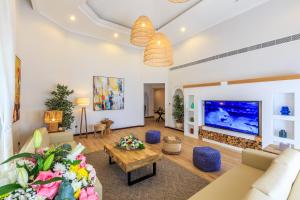 迪拜The S Holiday Homes - Stunning 5 Bedrooms Villa at the Palm Jumeirah with Private Beach and Pool的客厅配有大屏幕平面电视