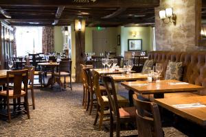 德罗伊特威奇哈德利鲍灵格林酒店的用餐室配有木桌和椅子